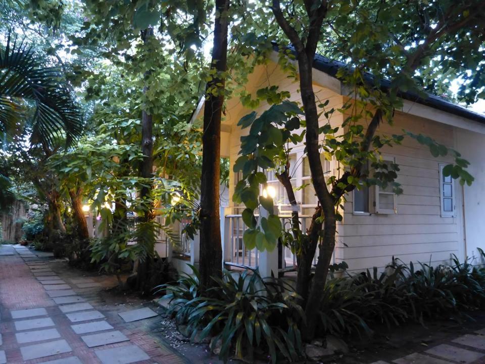 华欣Reera Resort的前面有树木和植物的房子