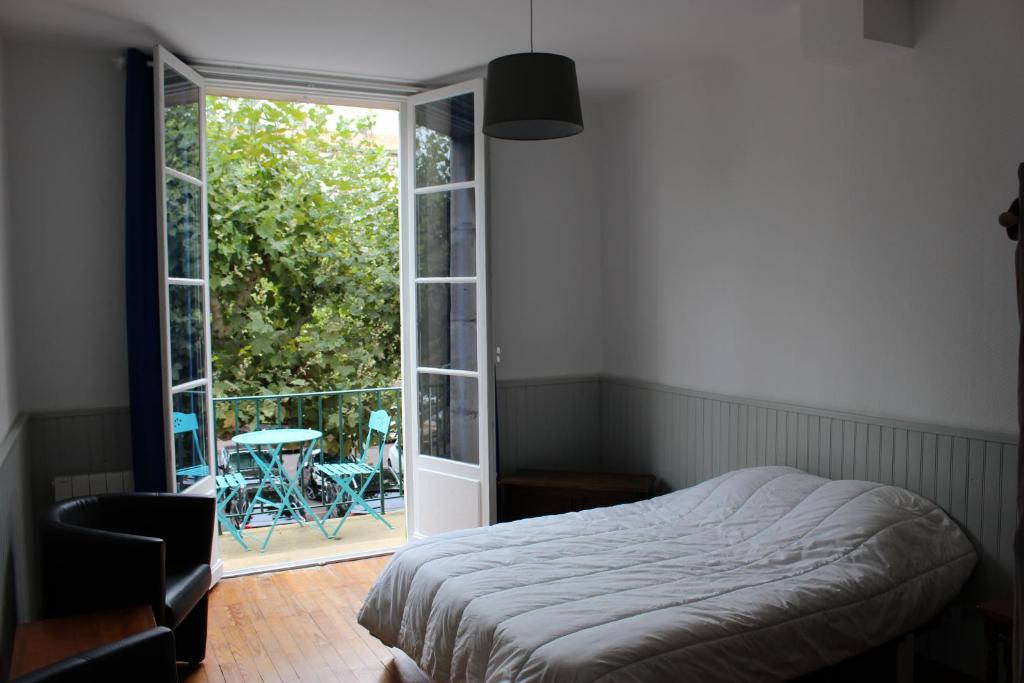鲁瓦扬Tout A Pied Au Coeur De Royan的一间卧室设有一张床和一个滑动玻璃门
