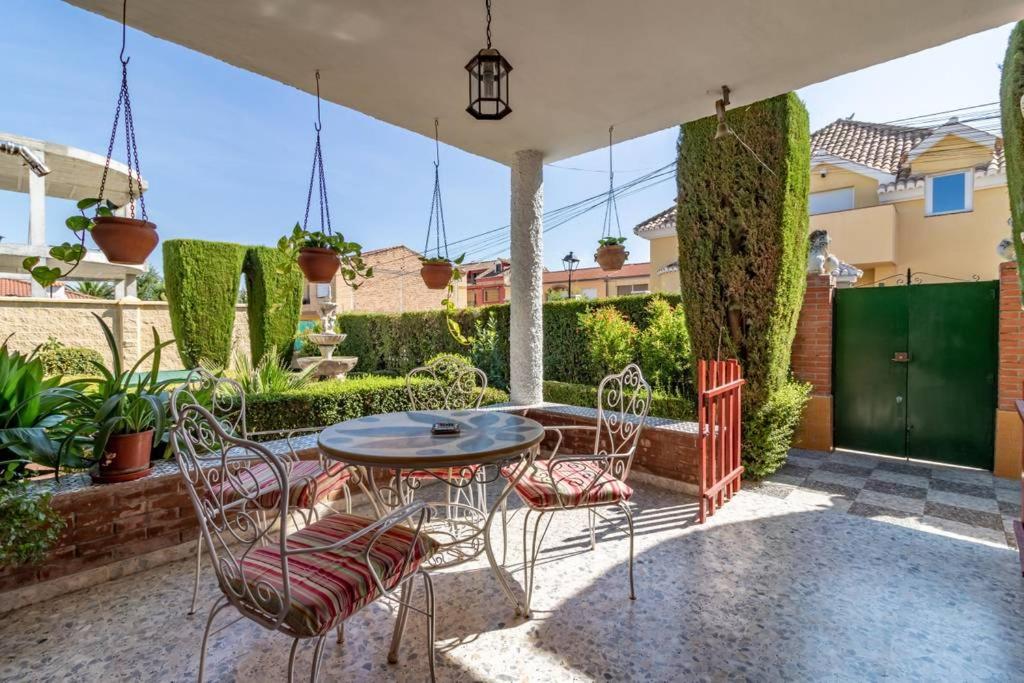 Churriana de la VegaChalet acogedor con piscina muy cerca de Granada的庭院配有桌椅和植物