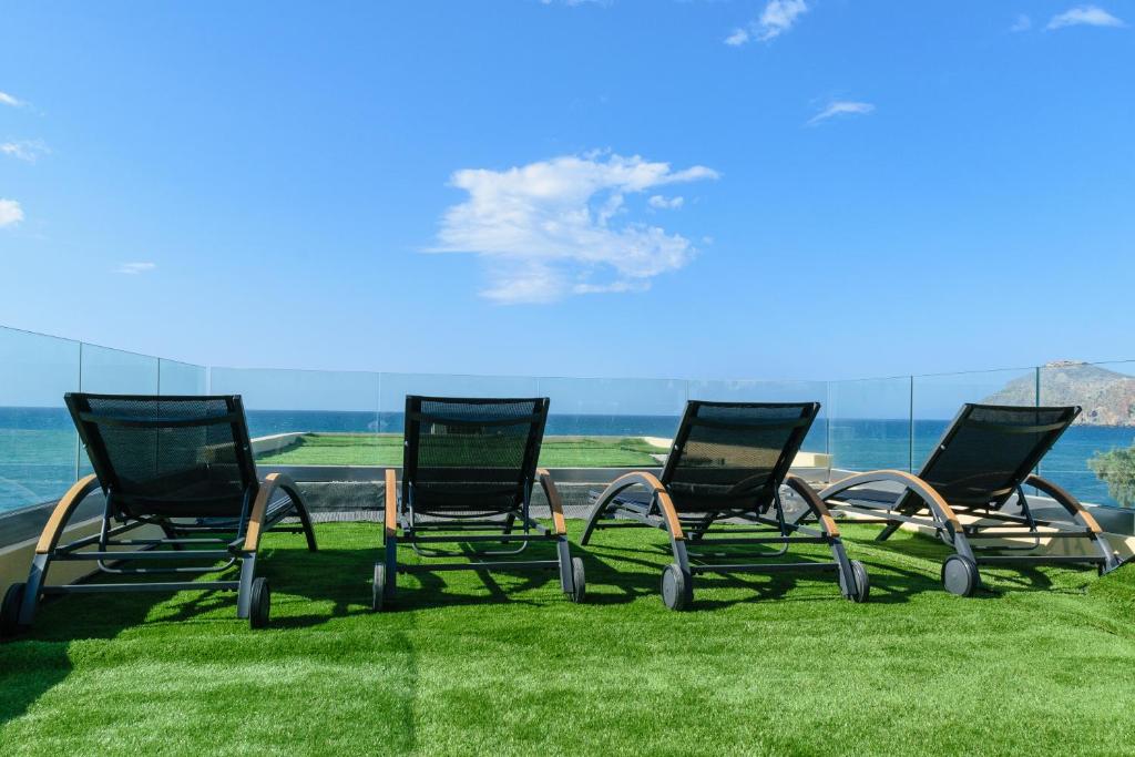 普拉塔尼亚斯Aetheras Beach的一群椅子坐在水边的草上