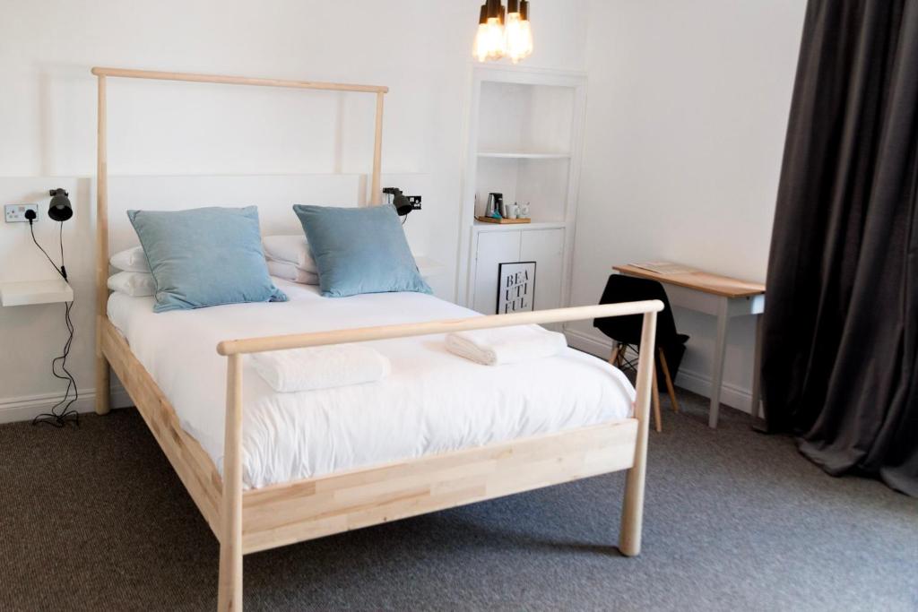 巴斯The Black Fox的一间卧室配有一张带蓝色枕头的木床。