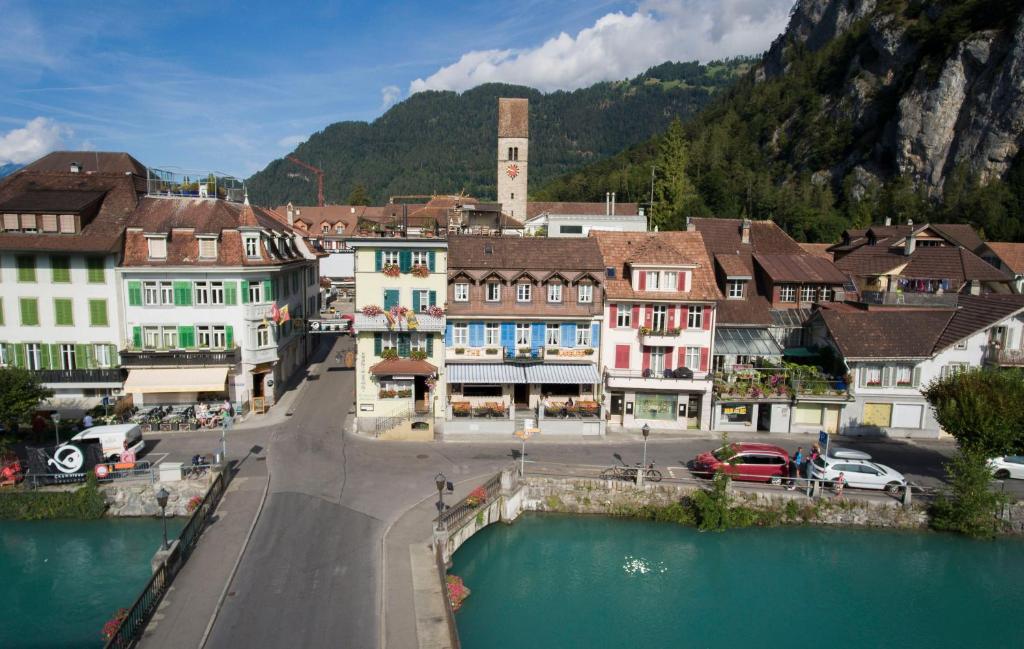 因特拉肯The Aarburg Hotel & Café的一座有河流、建筑和山的城镇