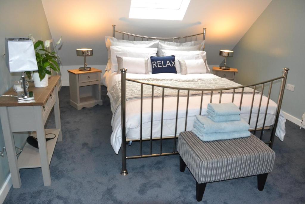 索尔兹伯里Little Dene Apartment的一间卧室配有一张带白色枕头的床和一张书桌