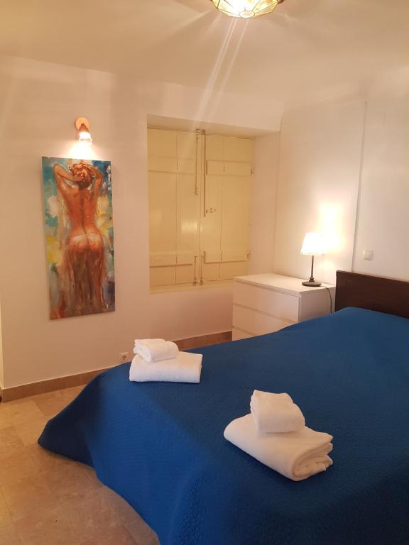 塞图巴尔Casa Visconde de Alcácer的一间卧室配有蓝色的床和2条毛巾