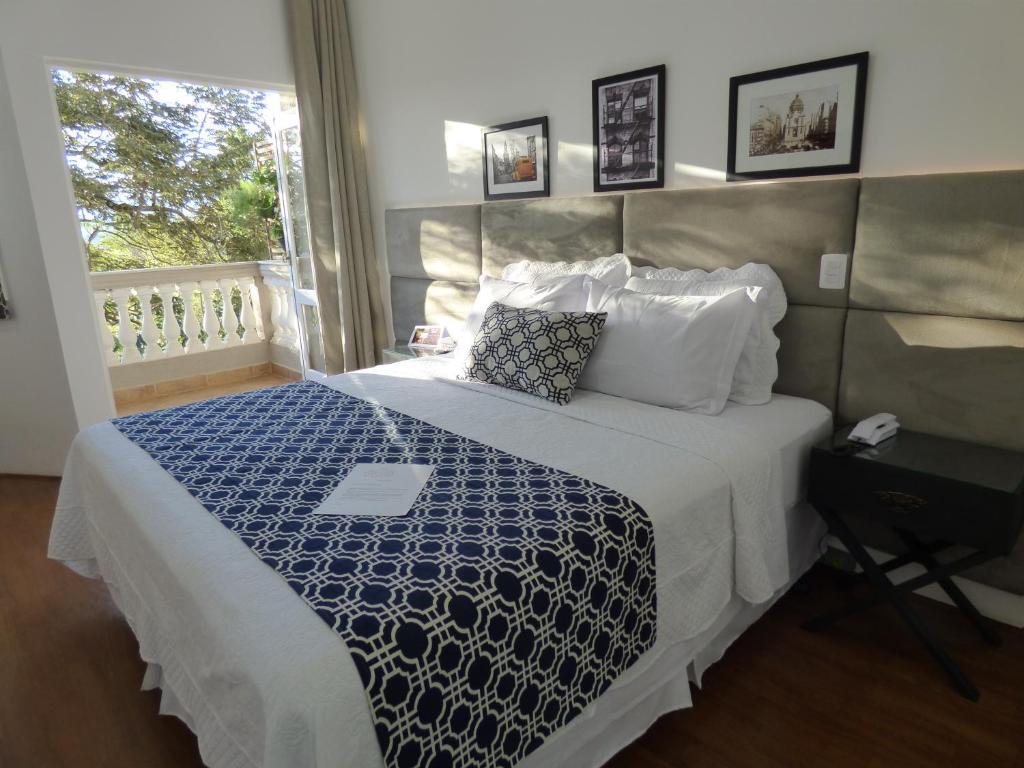 伊克斯雷玛Feliccità Pousada的一间卧室配有一张带蓝色和白色棉被的床