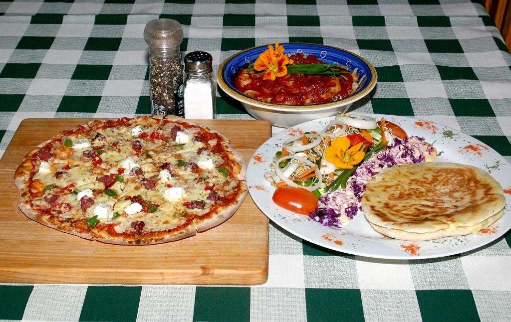 Ethels DriveTower of Pizza的一张桌子,上面放着两盘食物和比萨饼