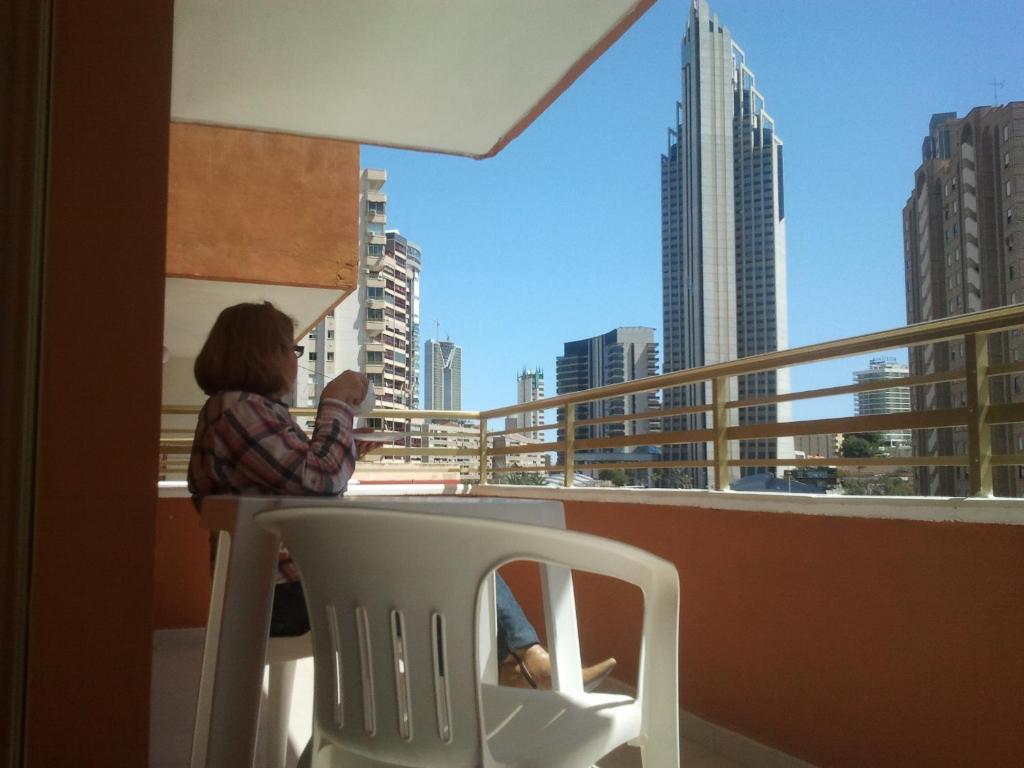 卡拉德费斯特拉特奥卡尼亚公寓酒店的坐在阳台上椅子上的女人