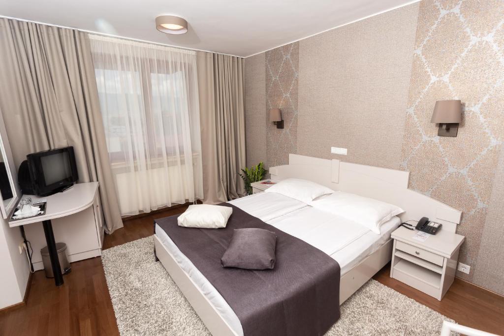 密古雷休治Hotel Fenyõ的卧室配有一张白色大床和电视。