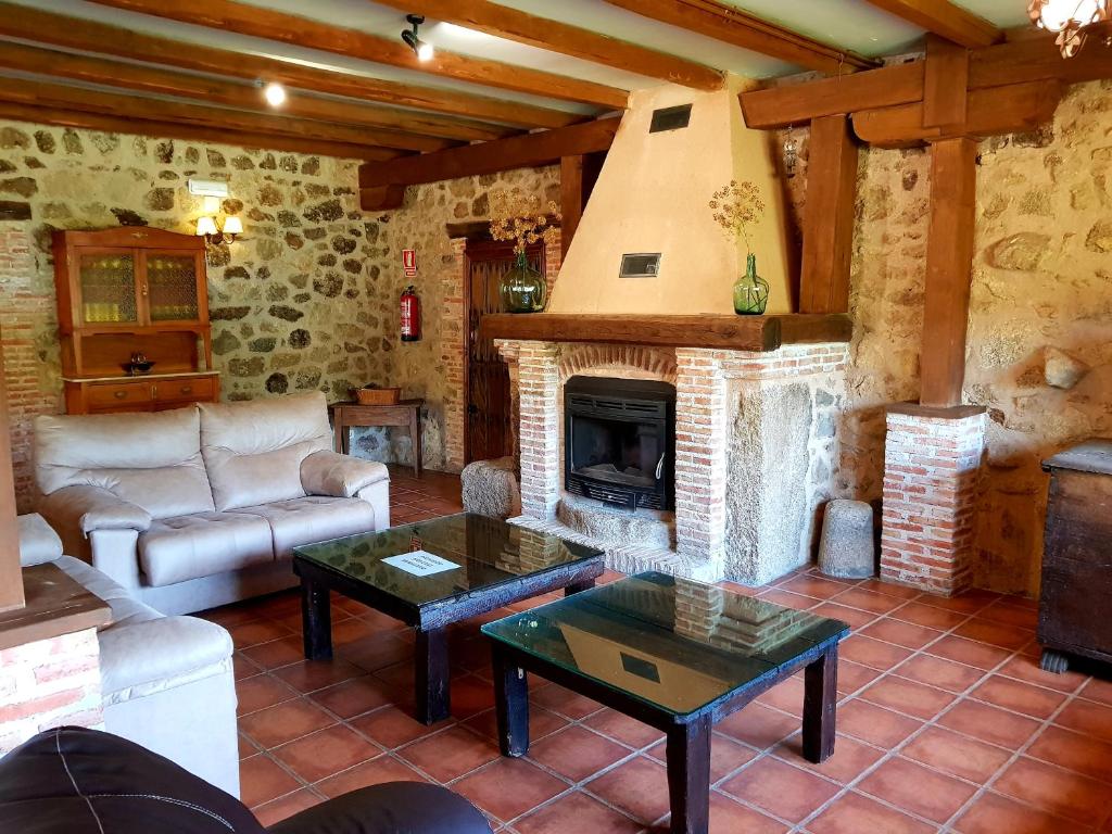 夸科斯德尤斯特Casa Rural Colmenarejo的带沙发和壁炉的客厅
