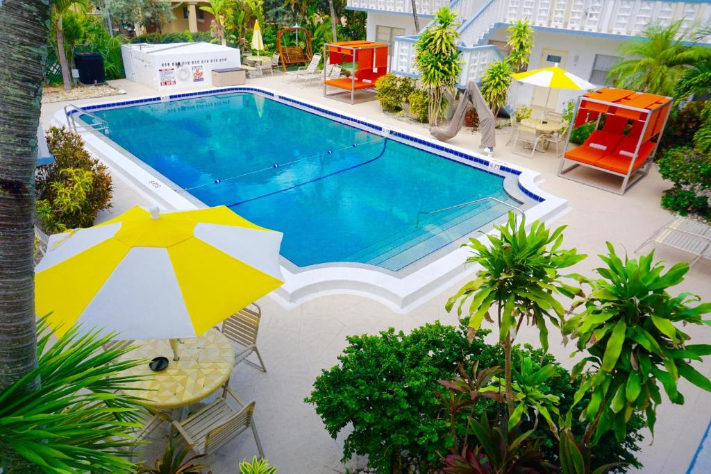 迪尔菲尔德海滩Club Lux Resort By The Beach的游泳池顶部景,带遮阳伞