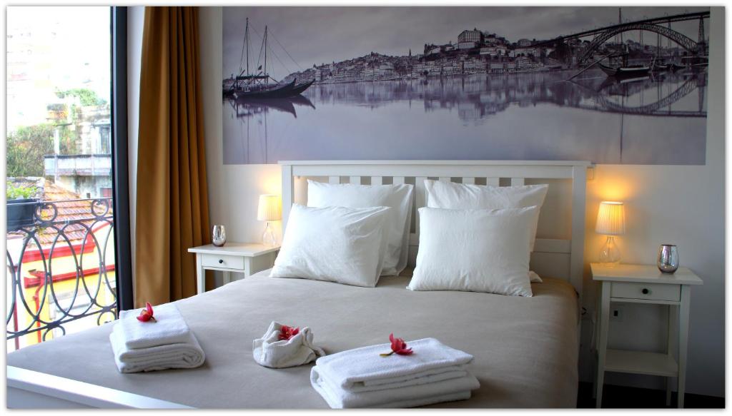 加亚新城盖亚波尔图旅馆的一间卧室配有带毛巾的床和窗户。
