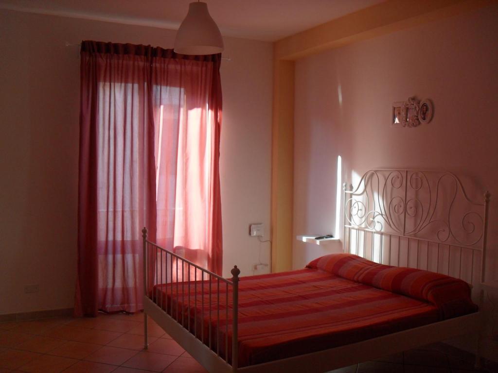 伊斯皮卡Casa Del Padrino的一间卧室设有红色的床和窗户。