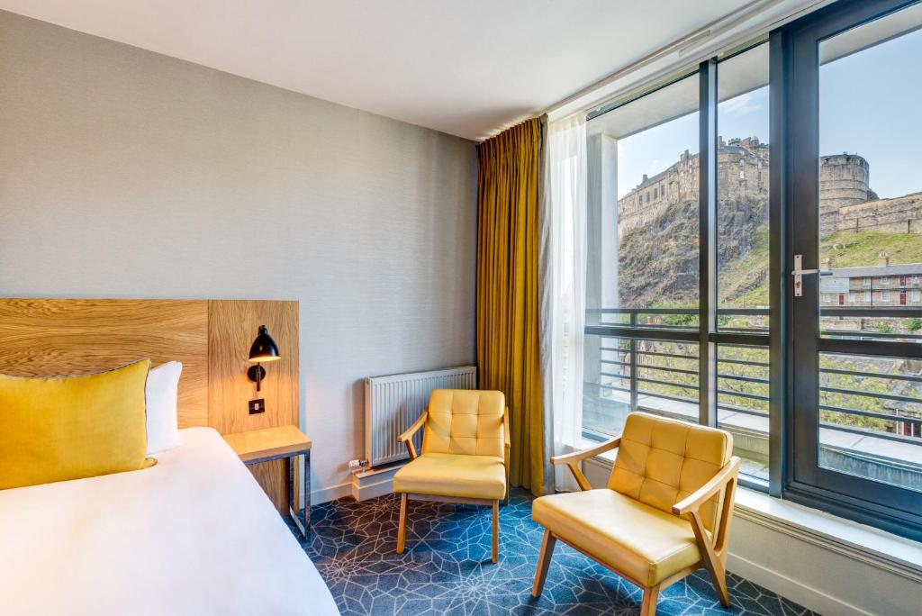 爱丁堡阿佩克斯跳蚤市场酒店的酒店客房设有一张床、两把椅子和一扇窗户。