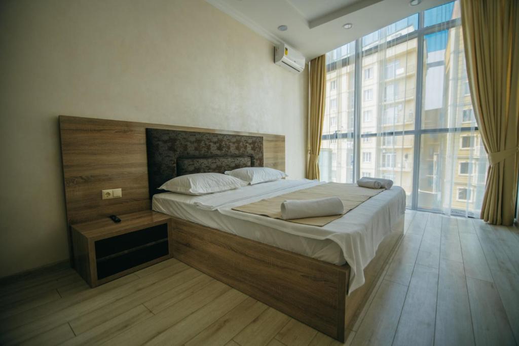 巴统Hotel Batumi Palace的一间卧室设有一张大床和一个大窗户