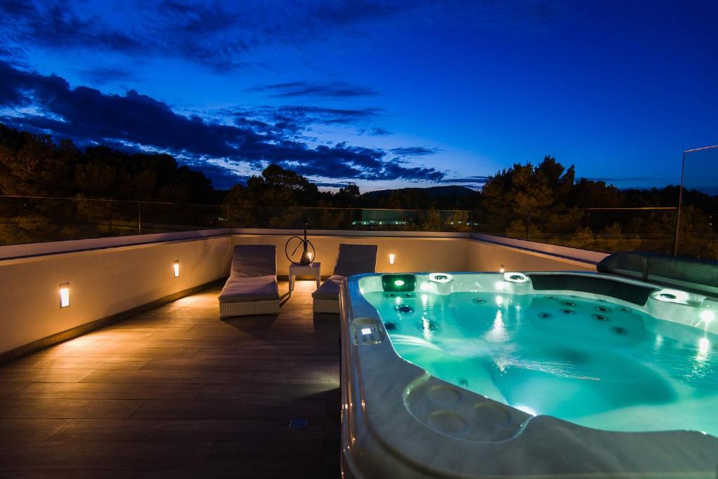 卡拉纳雅达Villa Can Nieves的夜间屋顶上的热水浴池