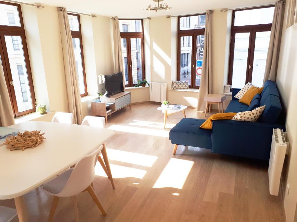 里尔Appartement 60m2 / Hyper Centre (Gares et Vieux Lille)的客厅配有蓝色的沙发和桌子