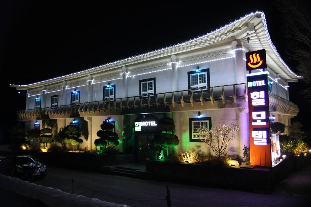 庆州山地汽车旅馆的前面有 ⁇ 虹灯标志的白色建筑