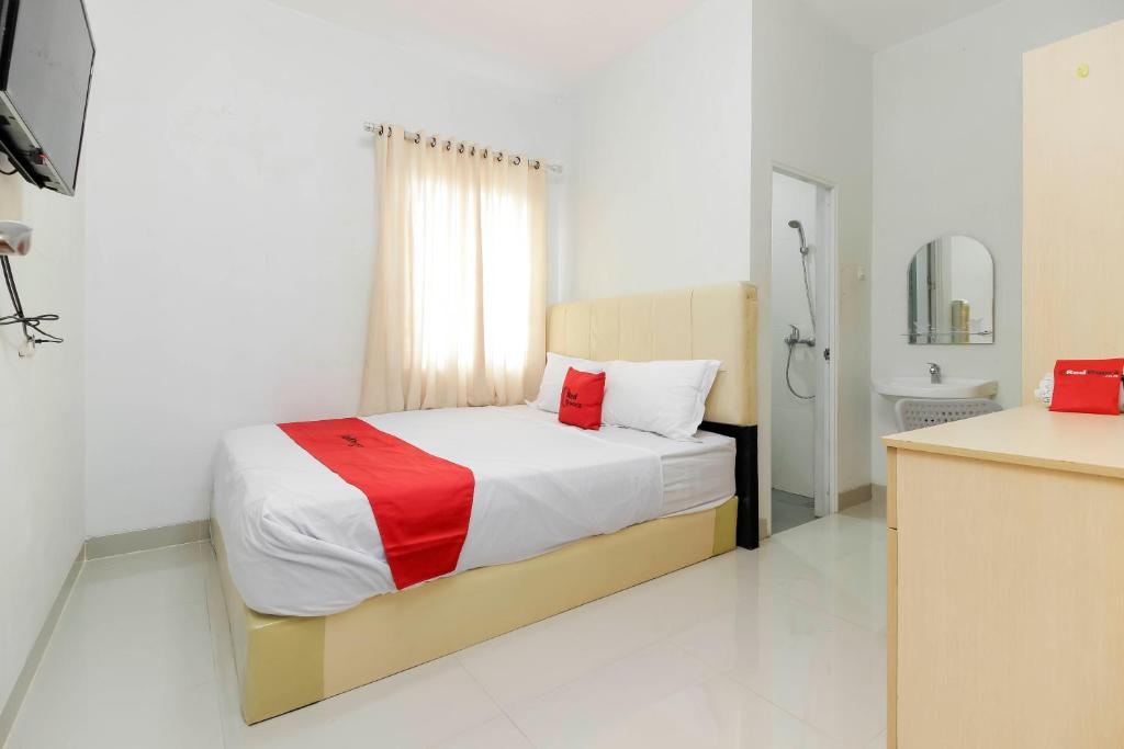 巨港RedDoorz near Siloam Hospital Palembang的一间卧室配有一张床,浴室设有水槽