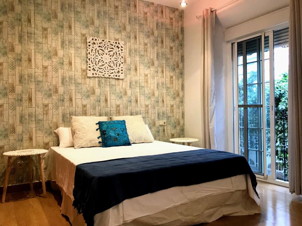 塞维利亚Triana Luxury Home的一间卧室设有一张床和一面墙
