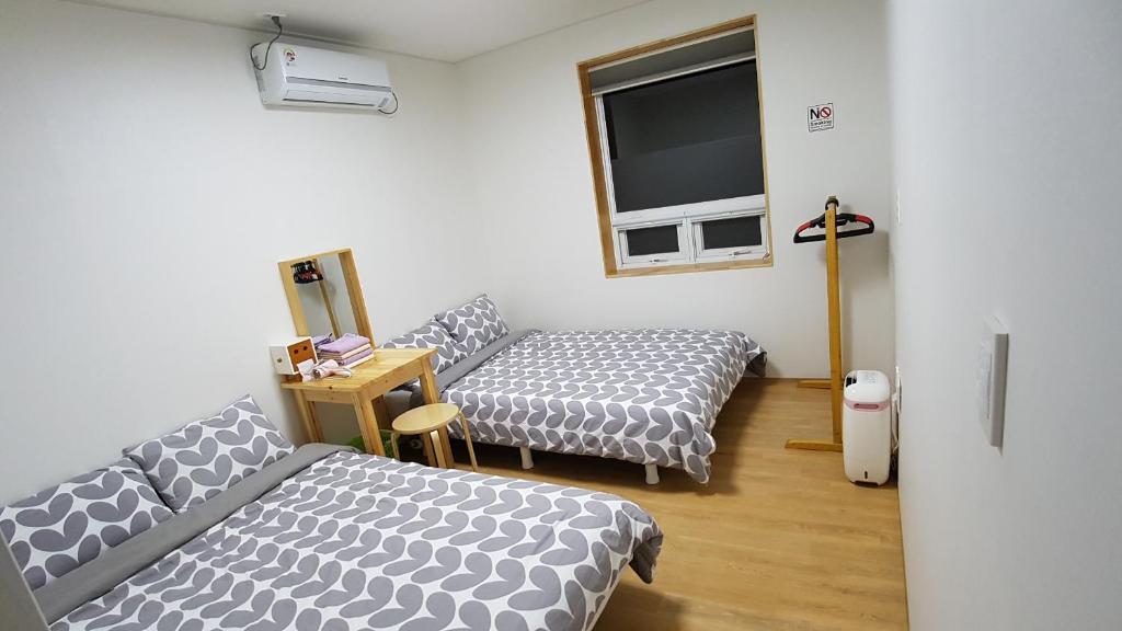 济州市邦旅馆的客房设有两张床和一台平面电视。