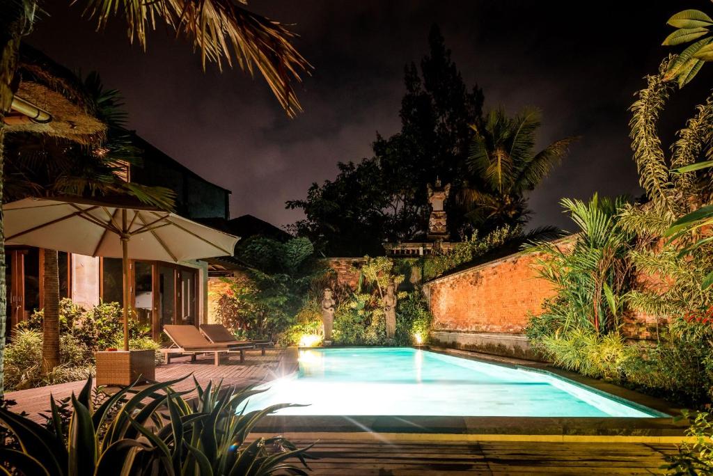 乌布卡兰甘度假屋的夜间在院子里的游泳池