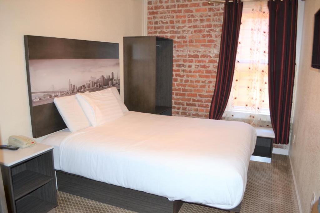 旧金山福尔瑟姆旅馆的卧室配有白色的床和砖墙