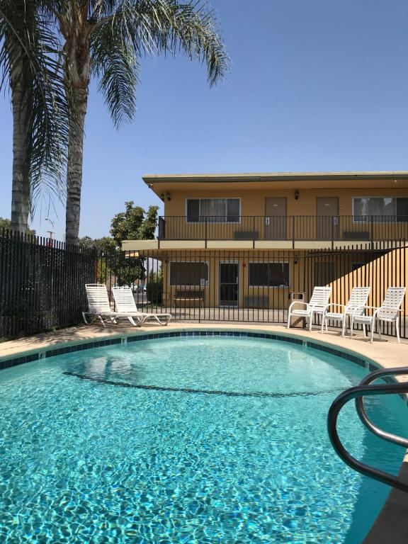 维塞利亚维萨利亚美国最有价值旅馆的一个带椅子的游泳池和一个背景建筑