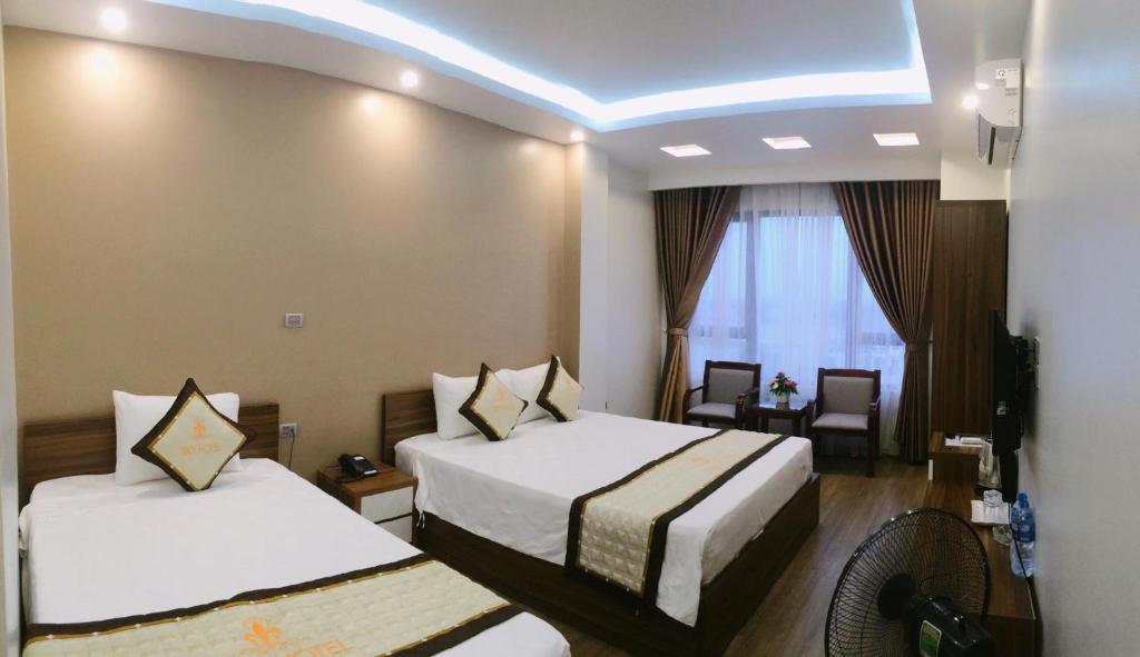 Uông BíSky hotel 390 QUang Trung Thành phố Uông Bí tỉnh Quảng Ninh的酒店客房设有两张床和窗户。