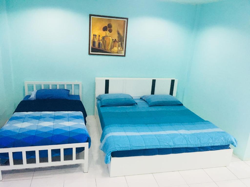 奈扬海滩最好订间房旅馆的蓝色墙壁客房的两张床