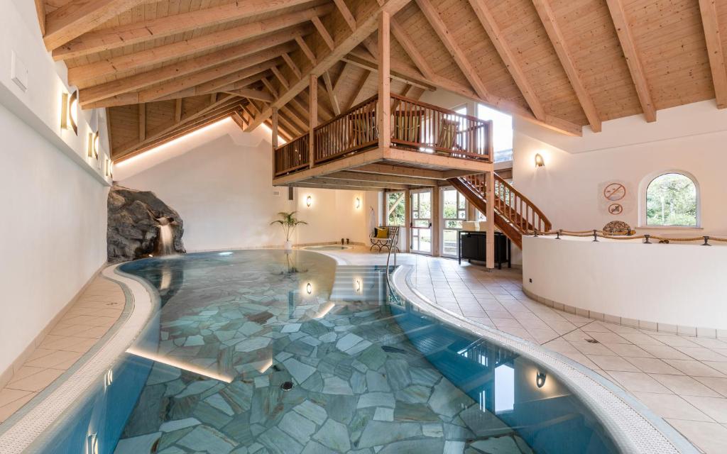 圣维吉利奥Sporthotel Exclusive的一座带天花板的房屋内的室内游泳池