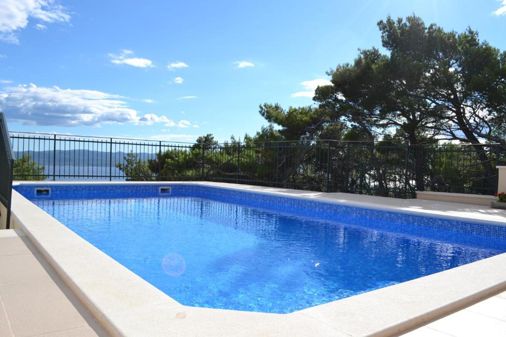 布雷拉Villa Grim的一个带栅栏和树木的蓝色游泳池