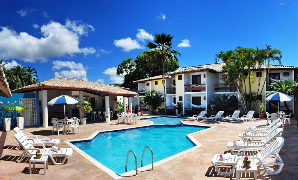 塞古罗港波尔图奥希阿诺酒店 的一座带游泳池和椅子的度假村和一座建筑