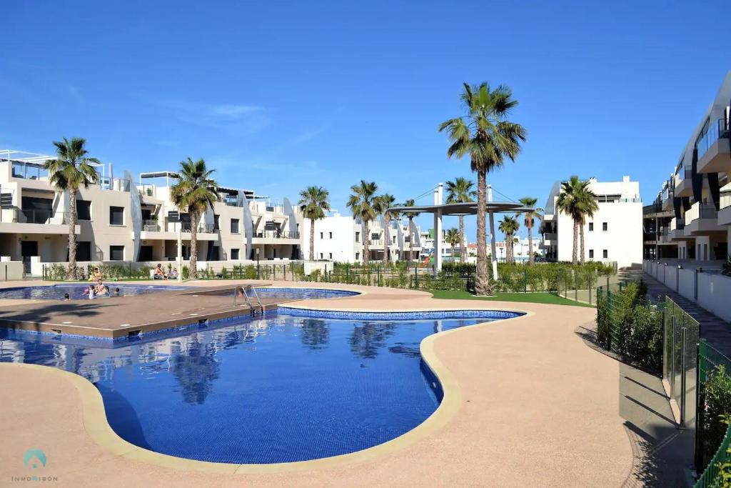 皮拉尔－德拉奥拉达达New Luxury Detached Villa with pool at beach的一座棕榈树和建筑的大型游泳池