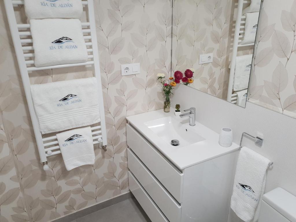 阿尔丹Apartamentos Ria de Aldan的白色的浴室设有水槽和镜子