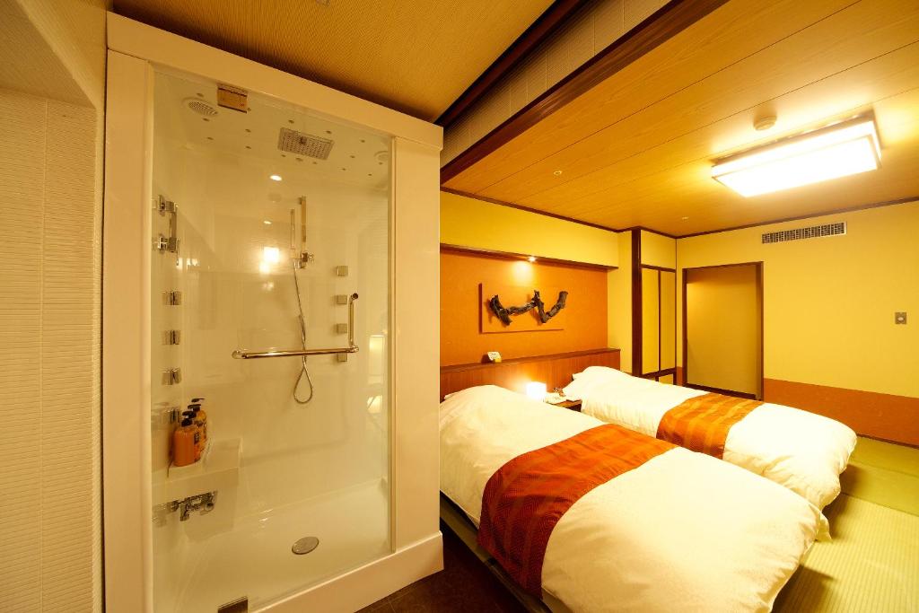 高知土佐御苑酒店的客房内的1间带1张床和淋浴的浴室