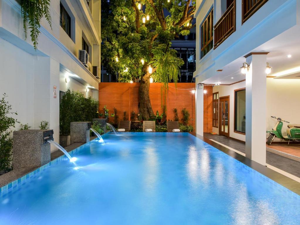 清迈兰纳树精品酒店的一座建筑物中央的游泳池