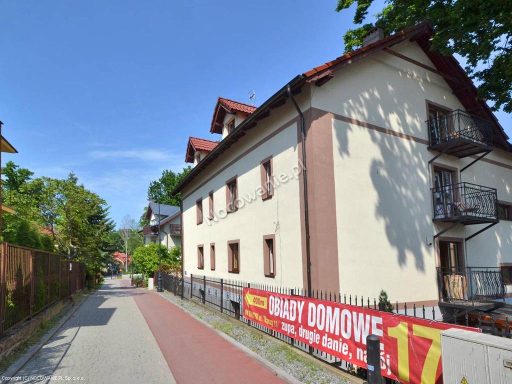 库瑞尼卡慕斯卡Pod Dębem的街道旁的白色建筑,有栅栏