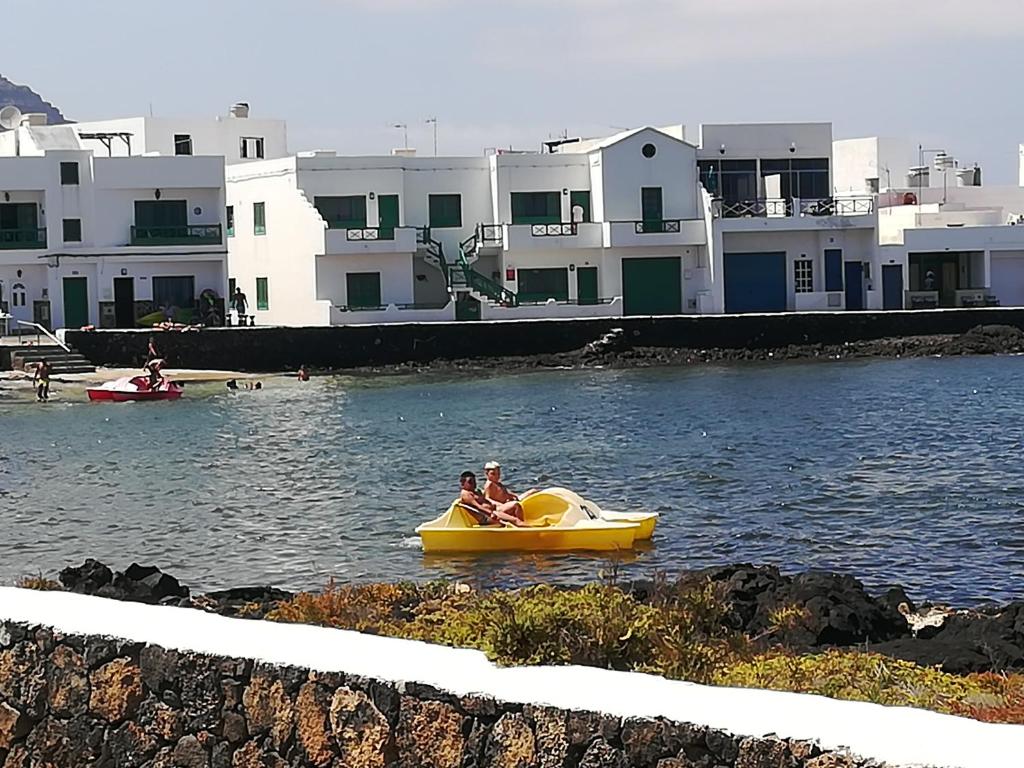 奥尔索拉Brisamarina de Órzola的两个人乘着一条黄色的船在水里