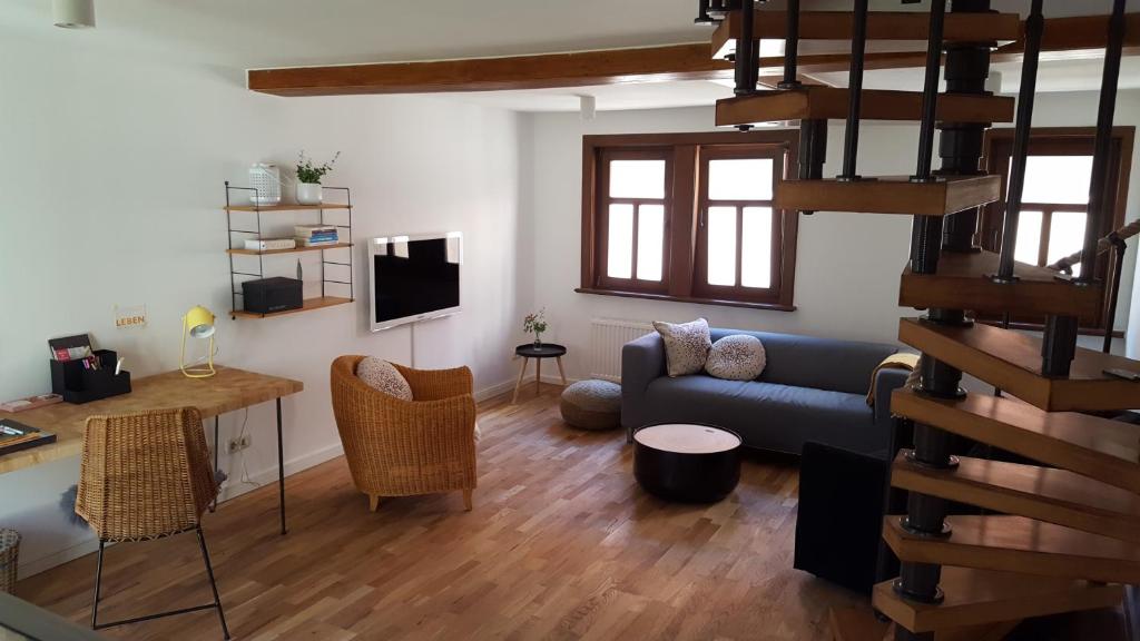 爱尔福特Haus zum wilden Manne的客厅设有蓝色的沙发和楼梯。