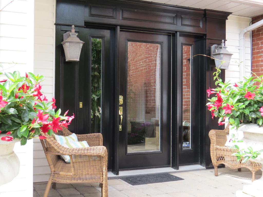 特伦顿Stone Garden Inn的黑色前门,带鲜花和藤椅
