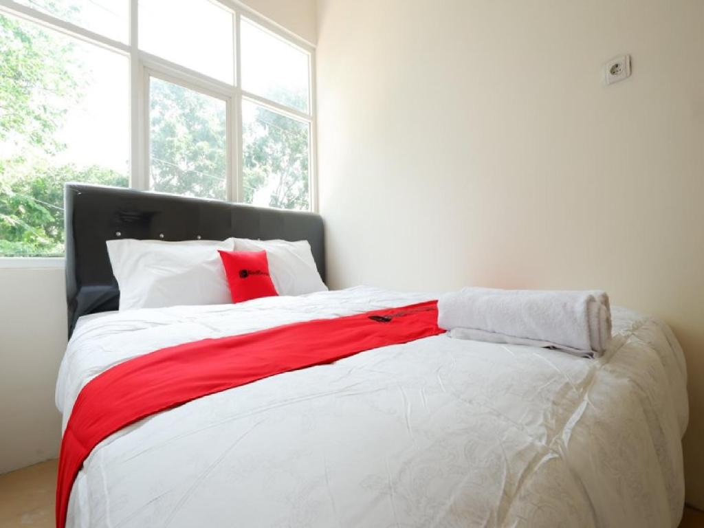 三宝垄RedDoorz near Akademi Kepolisian Semarang的卧室配有带红色枕头的大型白色床