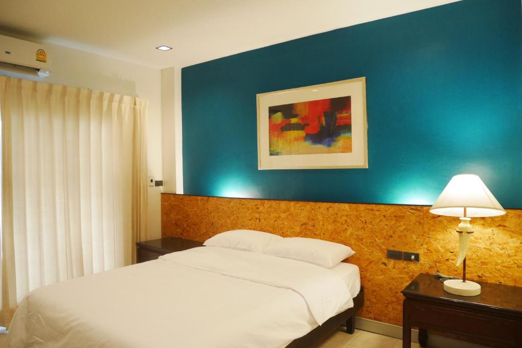 曼谷The 92 Residence的一间卧室设有一张床和蓝色的墙壁