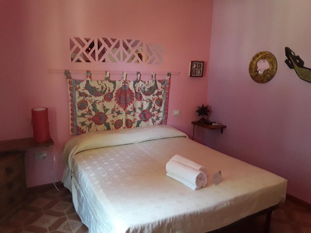 卡萨尔博迪诺伊尔特雷莫拉德拉玛莉娜酒店的粉红色的卧室,配有带两条毛巾的床