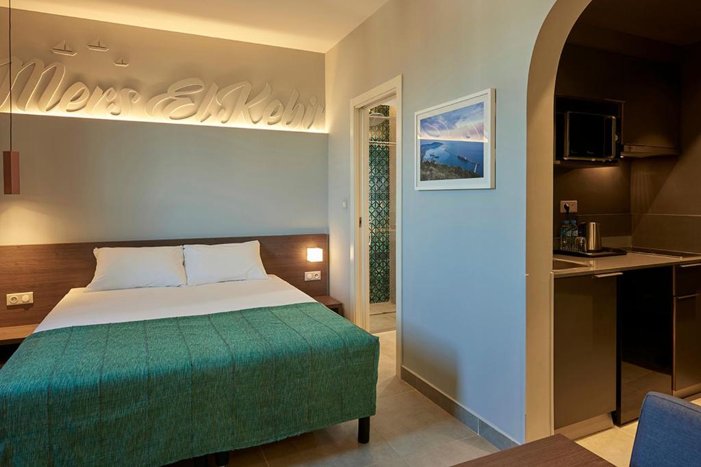 阿尔及尔M Suite Hotel的酒店客房带一张床和一个厨房