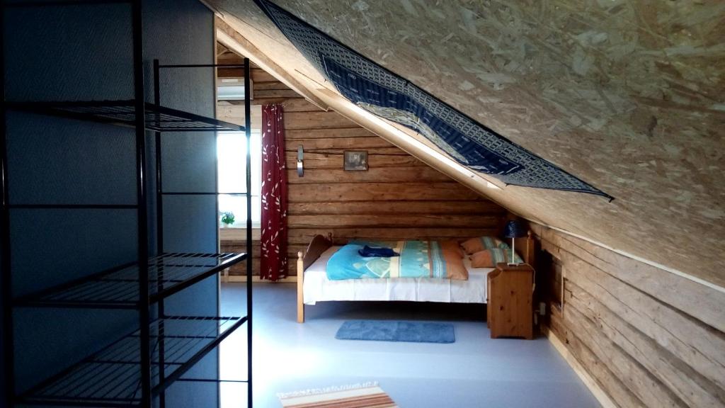 LungsjönVilla Moni的一间卧室设有一张床和木墙