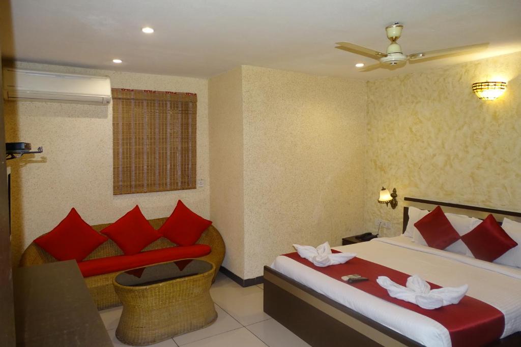 孟买Hotel Sunshine Airport的酒店客房,设有两张床和一张沙发