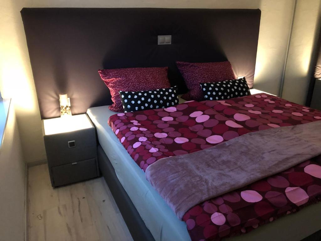 森海姆Am Weinberg的一间卧室,配有一张粉红色的床
