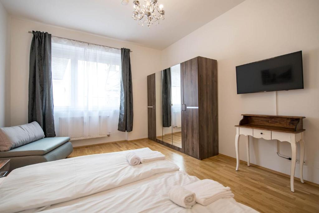 格拉茨Minihotel Graz Apartments的酒店客房设有两张床和电视。
