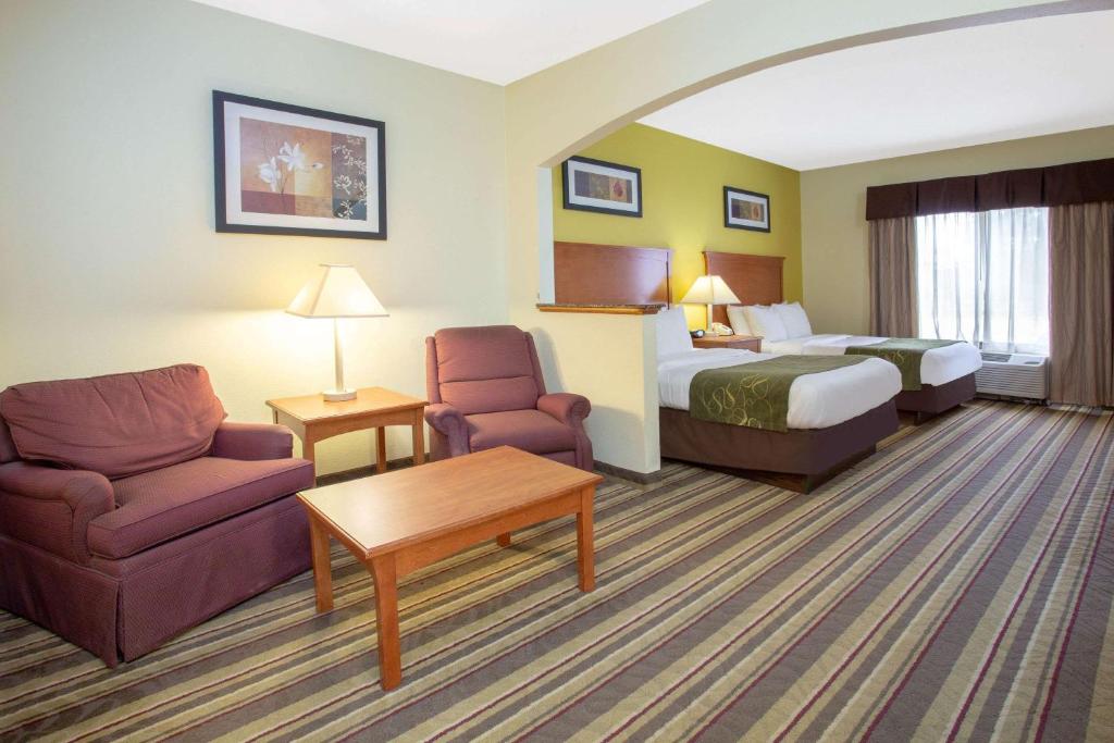 马里恩马里昂康福特套房酒店的酒店客房,配有床、沙发和椅子