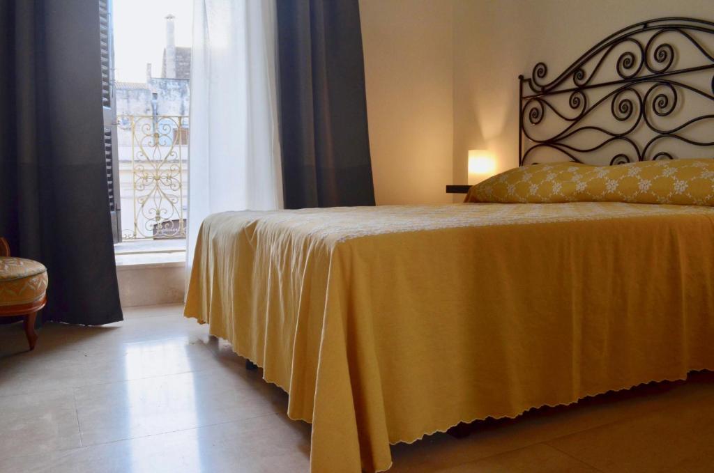 鲁蒂利亚诺Dimora Essenza的一间卧室配有一张带黄色毯子和窗户的床